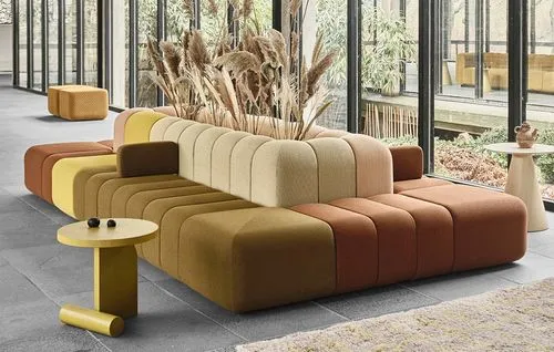 A large couch with a yellow and brown pillow on it.