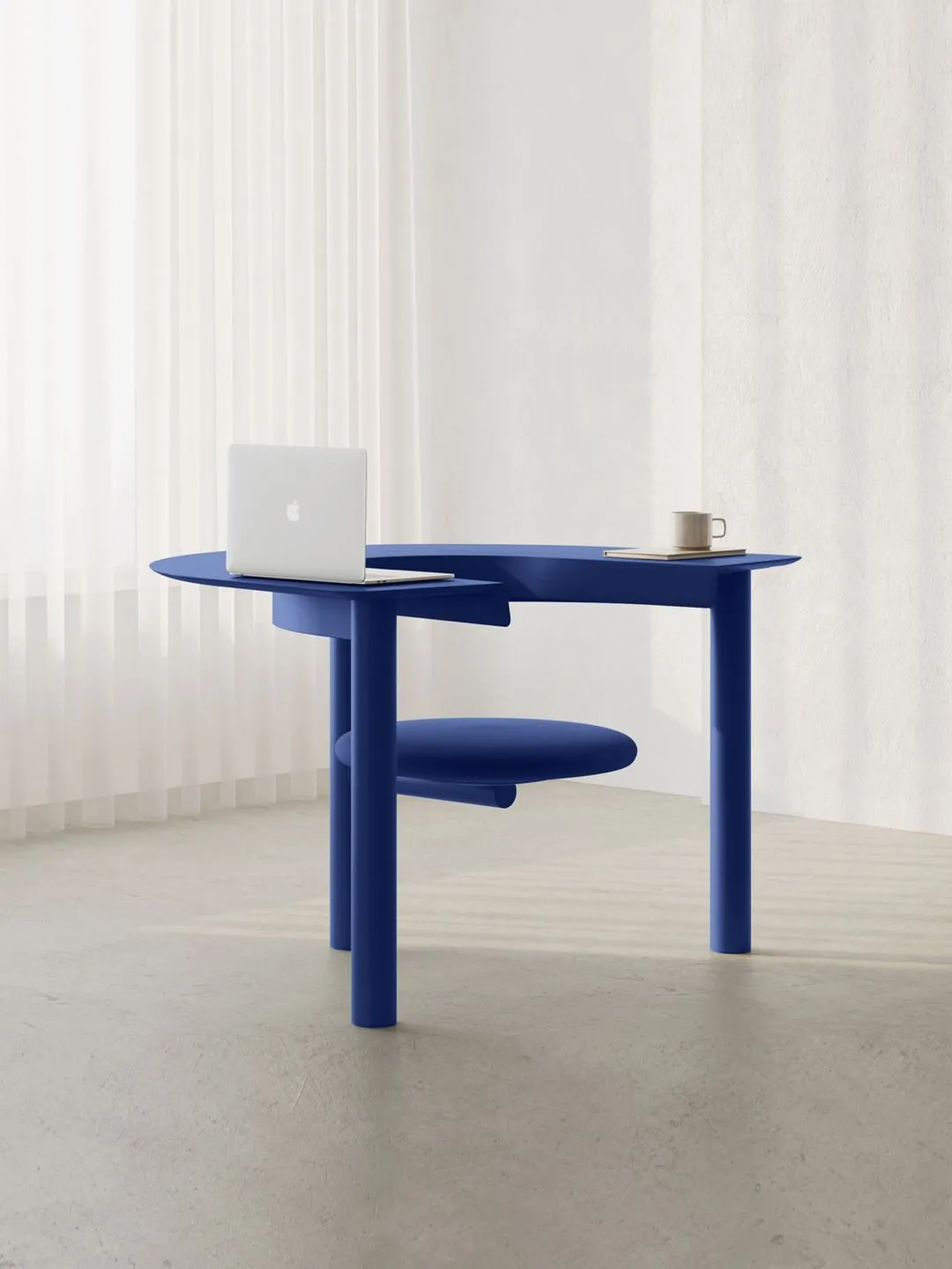 A blue desk with a laptop and a coffee cup on it.